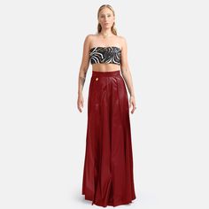 A hand pleated maxi skirt in red vegan leather featuring hidden zip closure and stylish golden embellishment. The lightweight fabric provides a relaxed, yet structured drape with a degree of stretch for added comfort and durability. The vertical pleating elongates the lower body for an elegant silhouette. An excellent choice for an stylish occasion where comfort is appreciated.  Made to order by qualified artisans in Australia. Organically Styled Hand Pleats  Maxi Length 60% PU 35% Polyester 5% Spandex Vegan Leather Sustainably Made in Australia Dry Clean Elegant Red Skirt For Night Out, Elegant Red Evening Skirt, Red Maxi Skirt For Night Out, Elegant Red High Waist Maxi Skirt, Elegant High Waist Red Skirt, Elegant Red Lined Skirt Bottoms, Luxury Evening Mini Skirt, Elegant Red Lined Skirt, Chic Red Maxi Skirt For Night Out