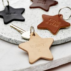 three personalized leather keychains on a marble tray