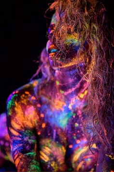 a man with long hair and holi paint on his body