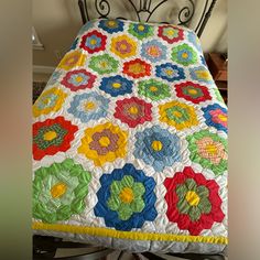 a bed with a colorful quilt on top of it