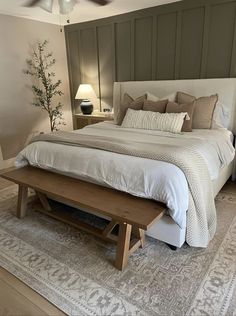 a bed with white sheets and pillows on top of it