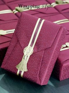 two purple boxes with tassels on them are sitting next to each other in rows