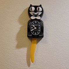 a black and white cat clock on the wall