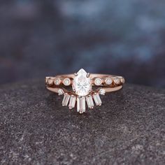 a close up of a ring on top of a rock with stones and diamonds around it