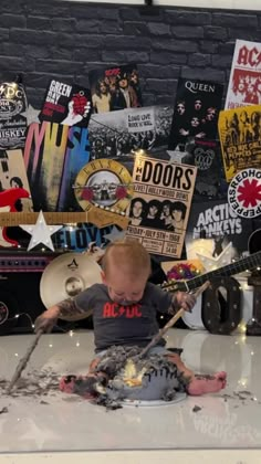 a baby is sitting on the floor playing with guitars