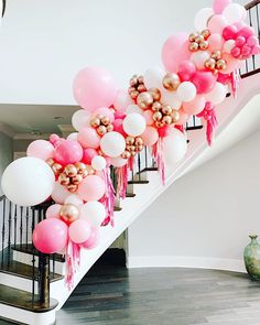 the staircase is decorated with balloons and tassels in pink, white and gold colors