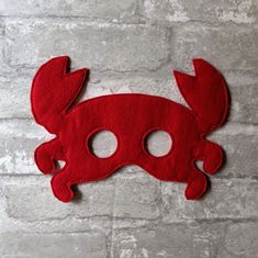 a red mask with two holes in the middle and one hole cut out to look like a crab