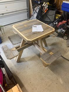 a wooden picnic table sitting inside of a garage