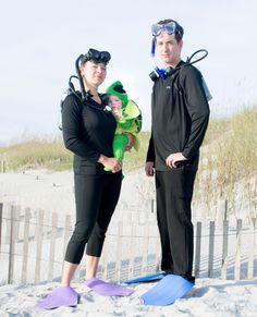 a man and woman in scuba gear standing on the beach