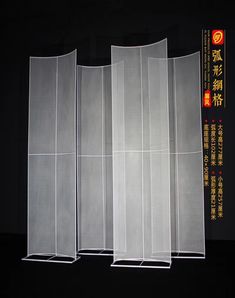 three tall white screens with chinese writing on them