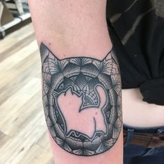 a tattoo on the arm of a person with a cat in it's center