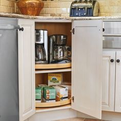 an open cabinet in a kitchen with appliances