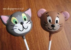 two cake pops decorated to look like cats