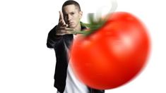 a man pointing at a large red tomato