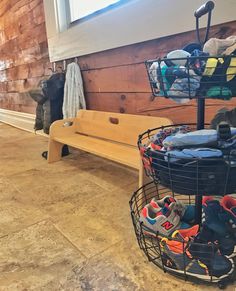 a wooden bench sitting next to a pile of shoes