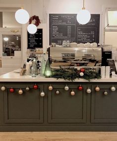 a coffee shop with christmas decorations on the counter and chalkboard menus behind it