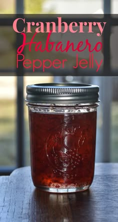 a jar filled with cranberry marmalade sitting on top of a wooden table