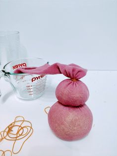 a measuring cup and some pink stuff on a table