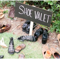 there is a sign that says shoe valet next to many pairs of shoes on the ground