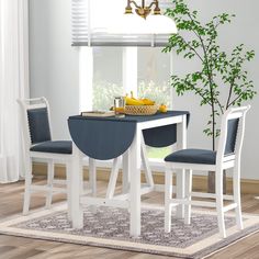 a dining table with two chairs and a bowl of fruit on the table next to it