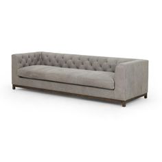 a gray couch with buttons on the back and arms, in front of a white background