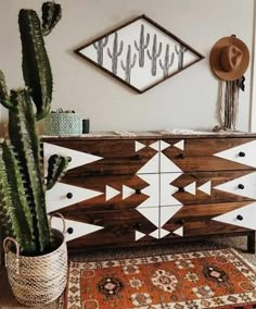 a large cactus sitting on top of a wooden dresser next to a mirror and rug