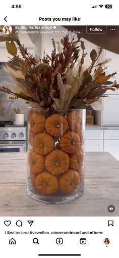 a vase filled with lots of oranges on top of a table