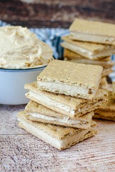 a stack of crackers sitting on top of a table next to a bowl of cream cheese