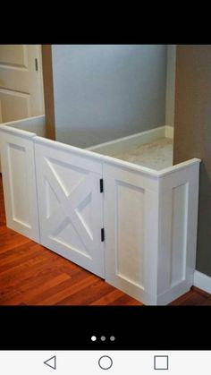 an empty room with a white cabinet and wooden floors