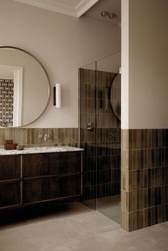 a bathroom with a sink, mirror and shower stall in it's center area