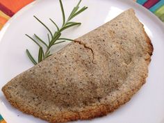 a piece of food on a plate with a sprig of rosemary