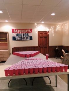 a bed with pink cups on top of it in front of a sign that says saturday's are for the girls