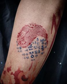 a man with a dragon tattoo on his arm that has writing written in chinese and english