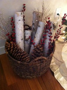 a basket filled with candles and pine cones on top of a wooden floor next to a christmas tree