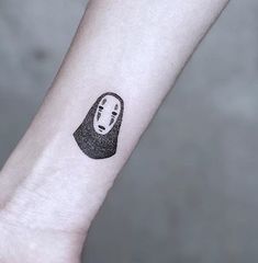 a black and white photo of a person's arm with a spirited ghost tattoo on it