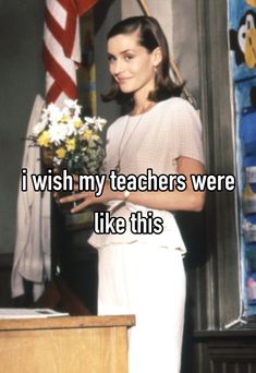 a woman standing in front of a desk with flowers on it and the caption, i wish my teachers were like this