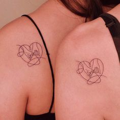 two women with tattoos on their backs holding hands and hearts in the shape of circles