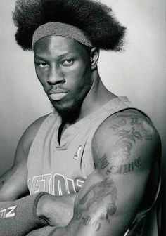 a black and white photo of a basketball player with his hair in an afro style