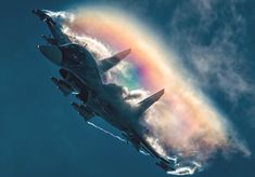 an airplane flying in the sky with a rainbow painted on it