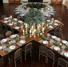 a large dining table set up with place settings and centerpieces for an event