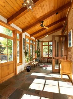 the inside of a house with wood paneling and large windows on either side of the room