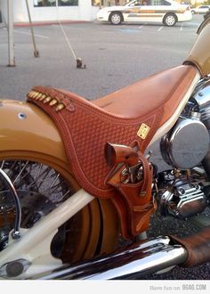 a brown horse saddle sitting on the back of a motorcycle