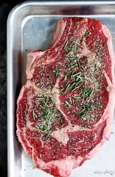 raw meat with herbs and seasoning on it sitting in a pan, ready to be cooked