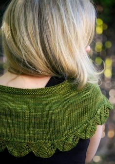 a woman with blonde hair wearing a green shawl