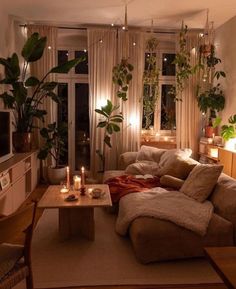 a living room filled with lots of furniture next to a window covered in plants and candles