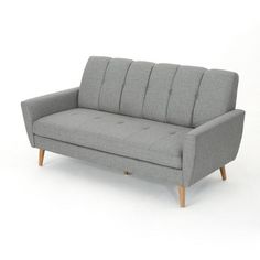 a gray couch sitting on top of a white floor next to a wooden leg chair