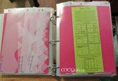 an open binder with pink and green papers