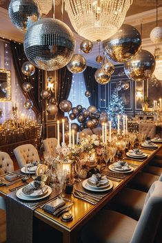 a dining room table is set with silver and gold decorations, candles, and plates