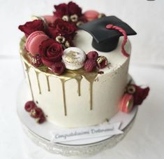 a decorated cake with flowers and a graduation cap on top