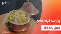 an image of food in the middle of arabic writing on a wooden table with a metal pot